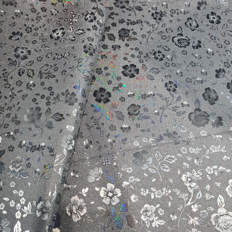 47x44cm BOLT END. Some Crease marks. Matte black with holographic flowers Faux leather / vinyl fabric.